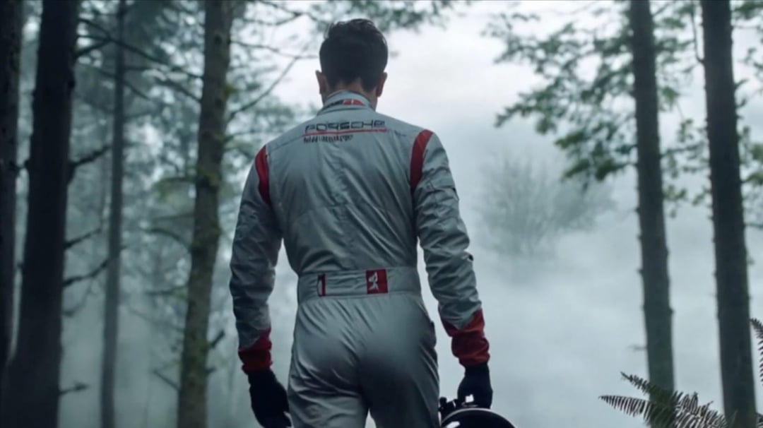 Eine Person in einem Rennanzug steht mit dem Rücken zum Betrachter in einem nebligen Wald und hält einen Helm. Stefan Aberer — © EASYdoesit.